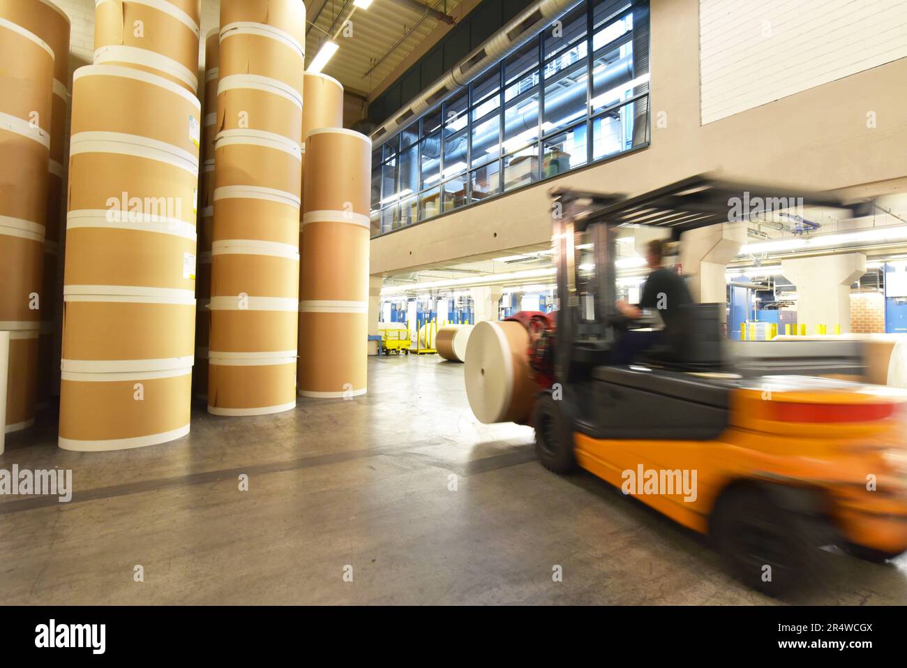 Lagerung von Papierrollen in einer großen Druckerei - Transport mit einem Gabelstapler Stockfoto