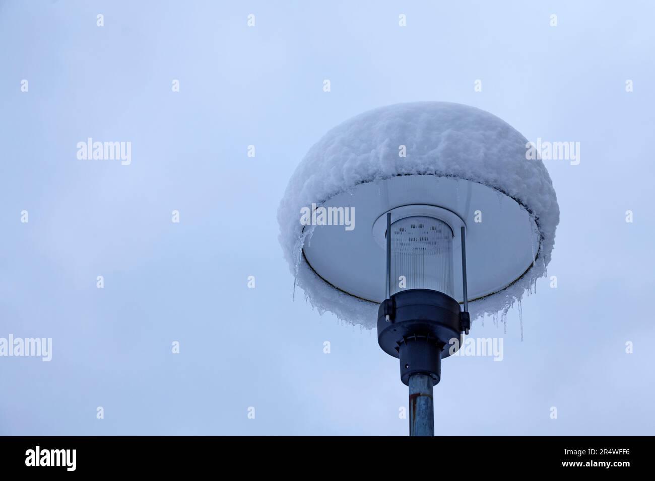 Straßenlampe im Winter mit Schnee und Eis bedeckt Stockfoto