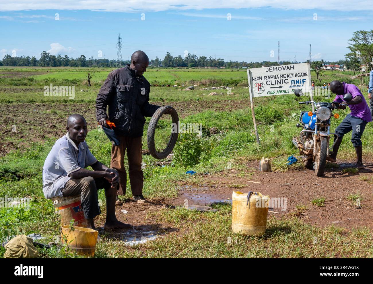 Zwei Männer stellten Motorradreparaturen am Straßenrand auf. Kenia, Afrika. Stockfoto