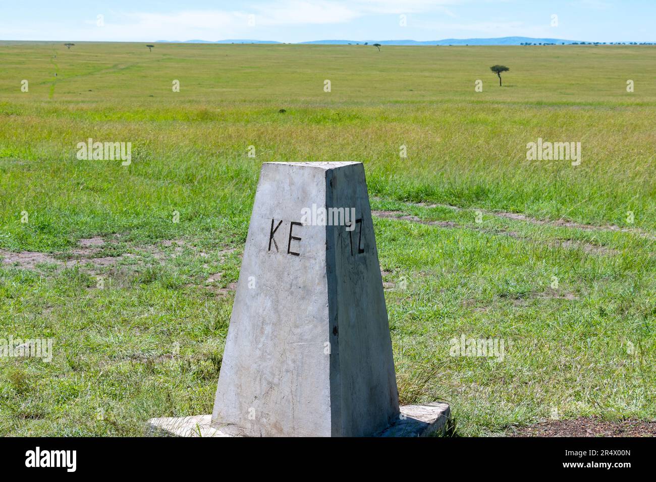 Betonschilder kennzeichnen die Grenze zwischen zwei Ländern Kenia und Tansania. Maasai Mara Nationalpark, Kenia, Afrika. Stockfoto