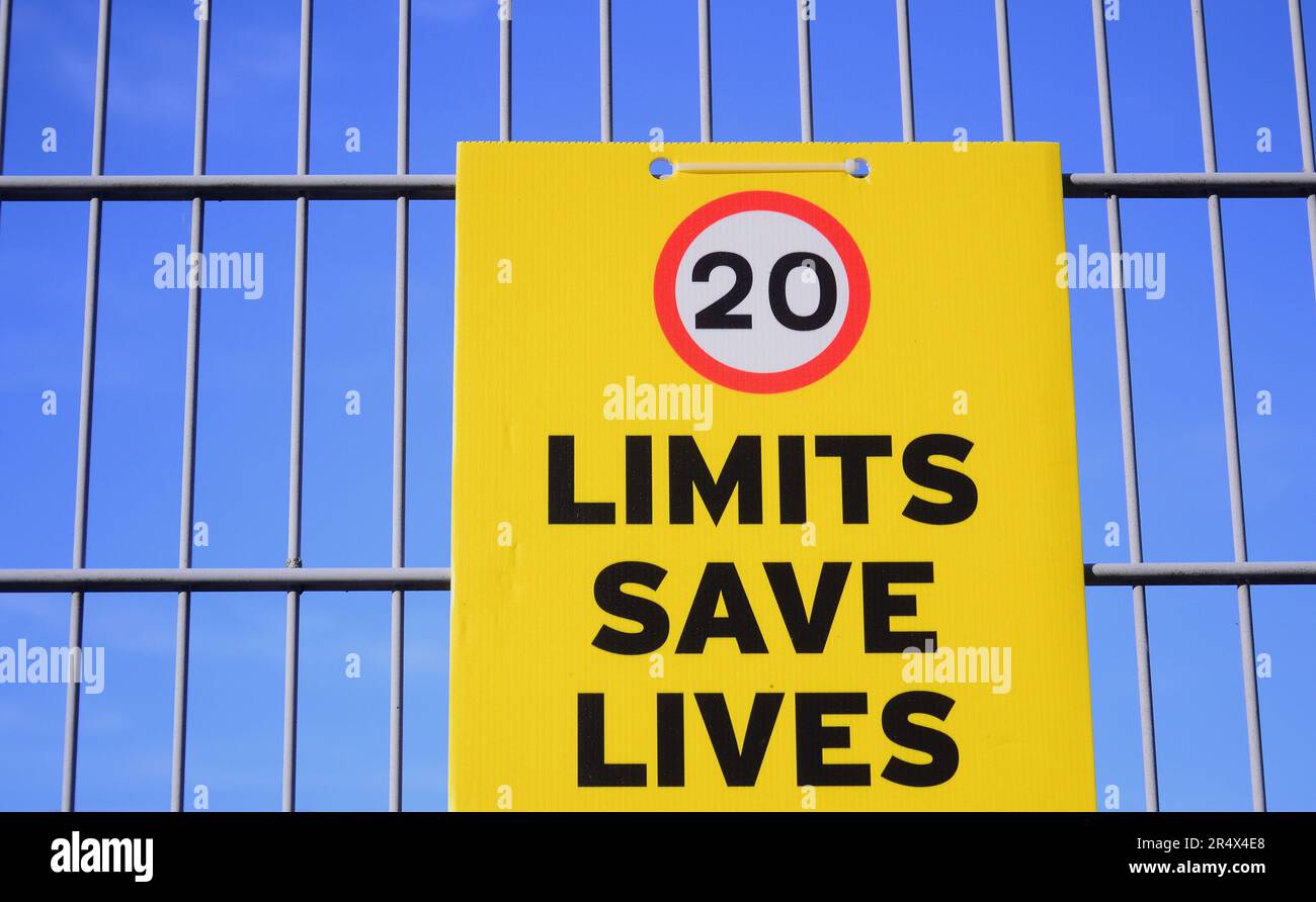 Tempolimit-Plakat „Limits Save Lives“ mit 20 km/h Bild am Zaun einer Schule in Manchester, Großbritannien Stockfoto
