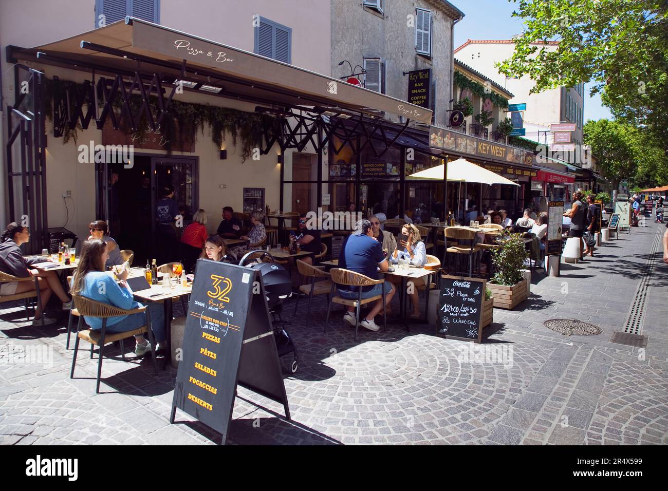 Frankreich, Provence-Alpen, Cote d'Azur, Antibes, Touristen sitzen vor Cafés und Bars in der Altstadt. Stockfoto