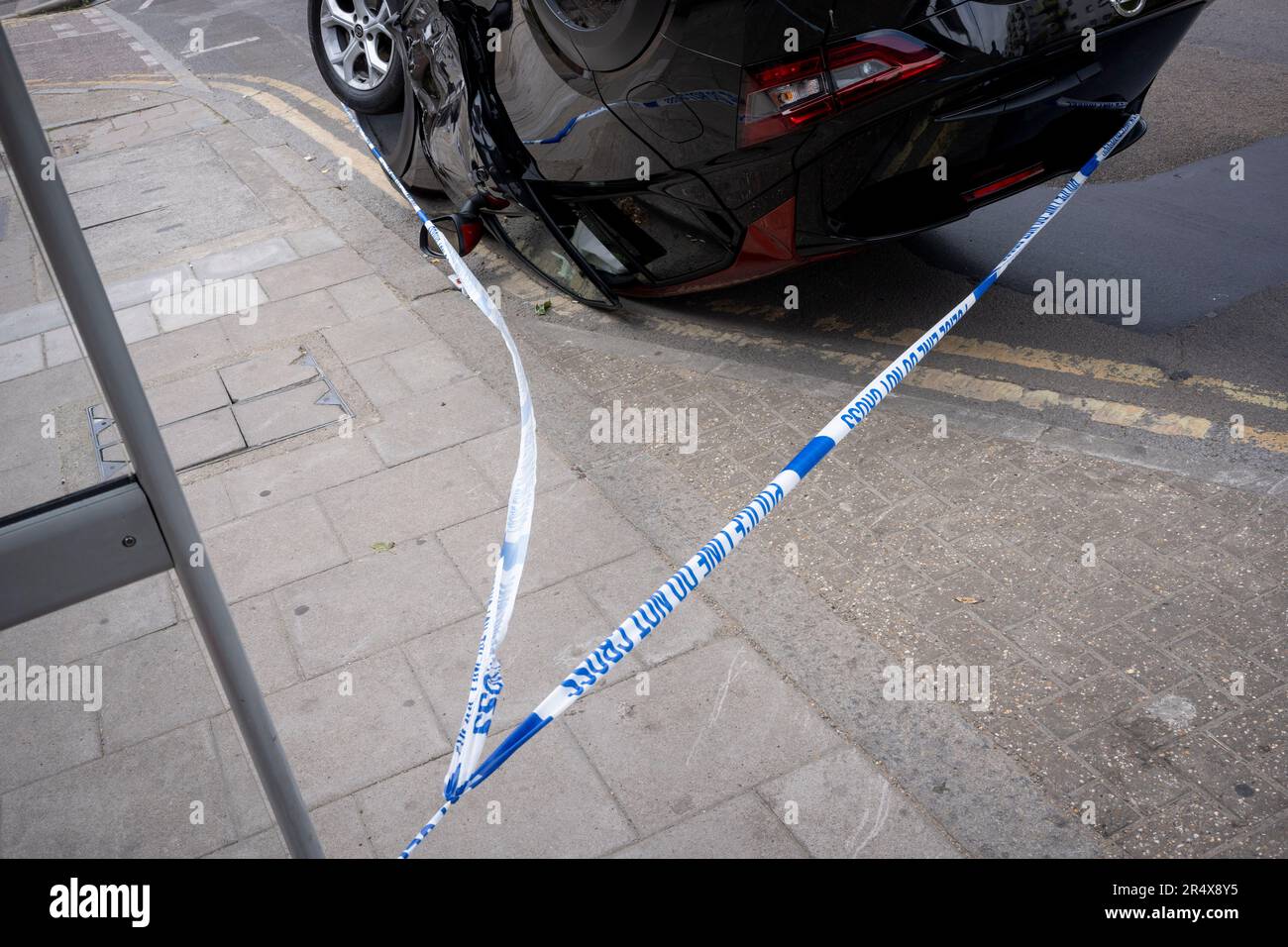 Das Polizeivideo umgibt die Folgen eines Autounfalls, bei dem ein umgestürzter Nissan-Heck an einer Bushaltestelle zwischen Brixton und Camberwell auf der Coldharbour Lane am 30. Mai 2023 in London, England, bleibt. Stockfoto