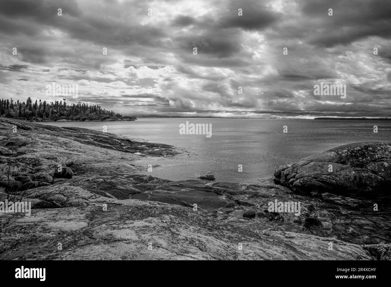 Dramatische Wolken über dem Lake Superior und eine felsige Küstenlinie im Infrarotbereich; Thunder Bay, Ontario, Kanada Stockfoto