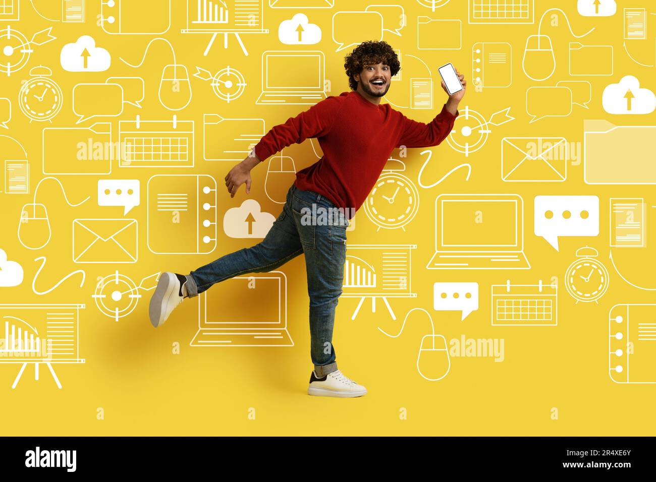 Lächelnder Mann mit Telefon, der über verschiedene digitale Weltsymbole läuft Stockfoto