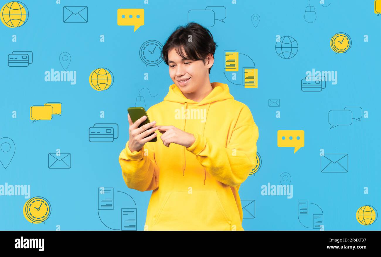 Lächelnder asiatischer Mann mit Telefon über diversen Ikonen der digitalen Welt Stockfoto