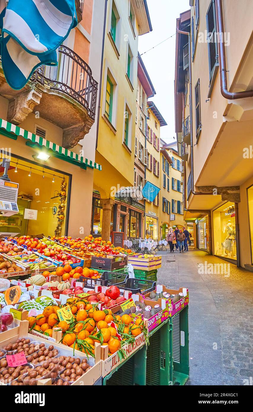 Der kleine Obststand mit frischen Orangen, Äpfeln, Kiwies, Granatäpfeln und anderen Früchten vor der engen Via Pessina, Lugano, Schweiz Stockfoto