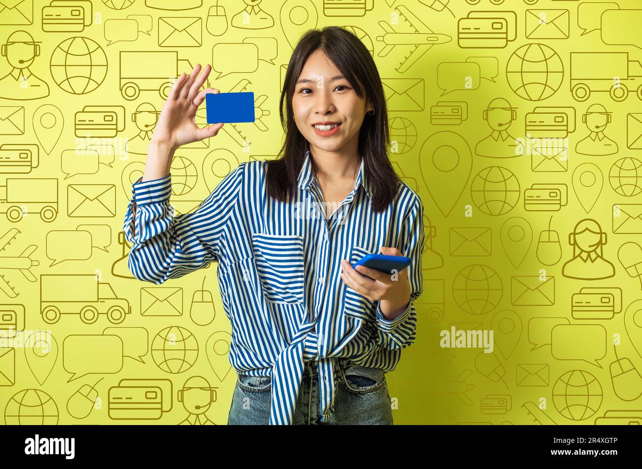 Lächelnde asiatische Frau mit Telefon und Bankkarte, Online-Banking Stockfoto
