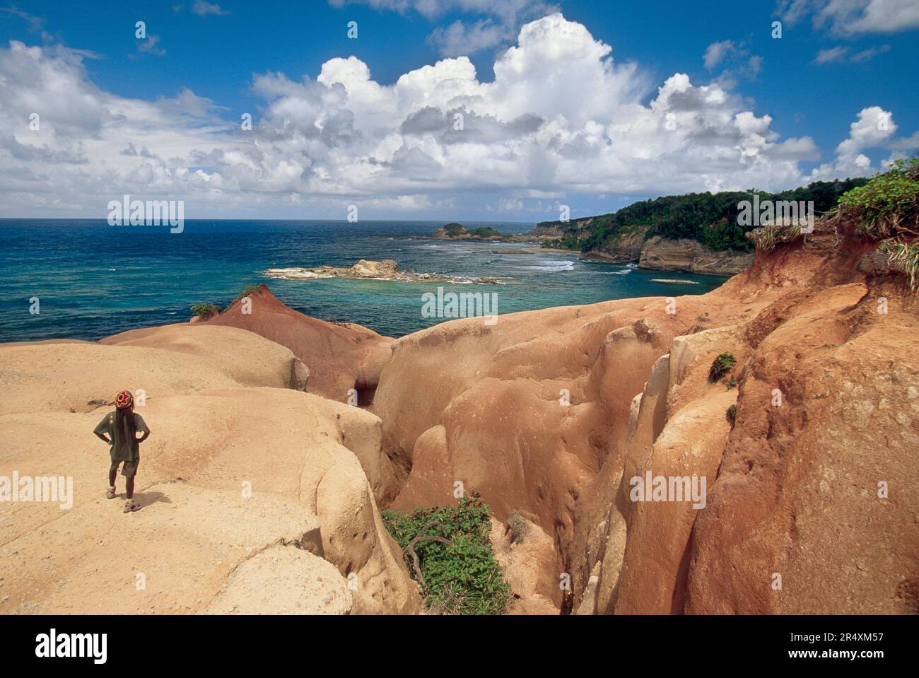 Der Mensch steht an einer felsigen, zerklüfteten Küste in Dominica mit Blick auf das Meer; Dominica Stockfoto