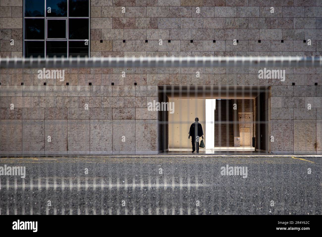 Mann, der durch einen modernen Gebäudeeingang läuft Stockfoto
