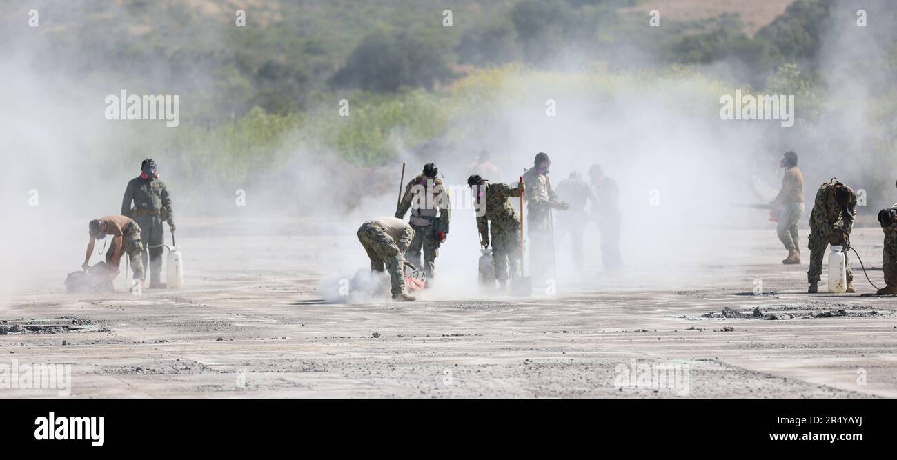 VANDENBERG WELTRAUMFORSCHUNGSBASIS, KALIFORNIEN (12. Mai 2023) Matrosen, die dem mobilen Naval Construction Battalion (NMCB) 4 zugeteilt wurden, und Marines, die dem Stützschwadron 372 der Marine Wing zugeteilt wurden, verwenden Betonsägen, um Krater von einer beschädigten Landebahn auszuschneiden und sie auf neues Material vorzubereiten. Die NMCB 4 führt derzeit Feldübungen durch, um zum einsatzbereiten Bataillon für das Verantwortungsgebiet des indopazifischen Kommandobereichs zu werden. (US Navy Foto von Mass Communication Specialist 2. Class Dakota Rayburn) Stockfoto