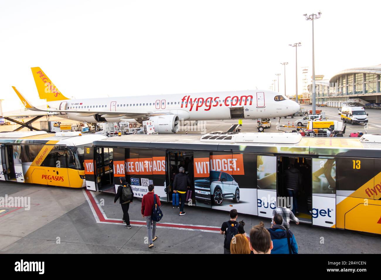 Passagiere, die in einen Shuttlebus vom Pegasus Flugzeug zum Flughafen auf Tarmac, Sabiha Gokcen International Airport, Istanbul, Türkei einsteigen Stockfoto