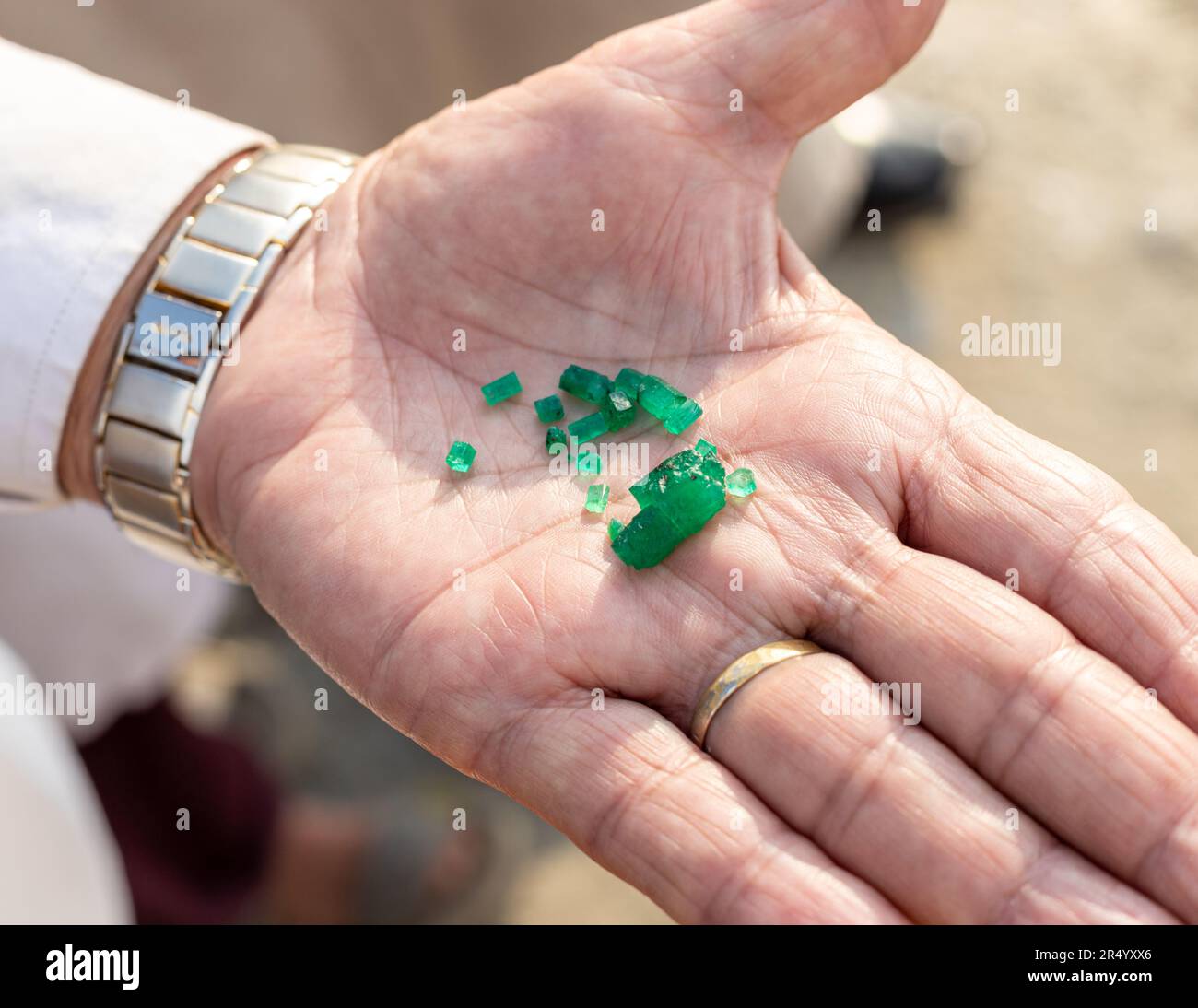 Ein Mann zeigt ein paar grobe, ungeschnittene Smaragde Kristalle in der Hand aus der Swat Smaragd-Mine in Pakistan Stockfoto