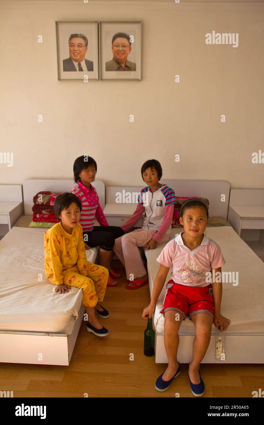 nordkoreanische Waisen in einem Waisenhaus vor den Bildern der Führer in nordkorea Stockfoto