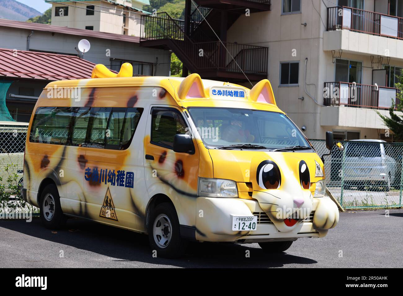 Kinugawa, Japan - Mai 2 2023: Katzenförmiger Schulbus in der Nähe des Kindergartens in Kinugawa, einer japanischen Landstadt. japan erlebt Subersatzfruchtbarkeit, Agin Stockfoto