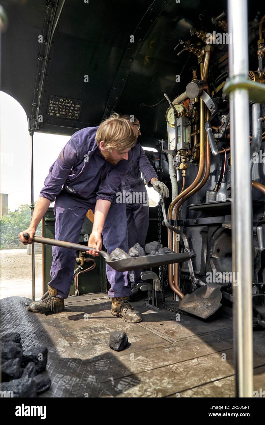 Dampfzug UK mit Feuerwehrmann, der Feuer auf dem Earl of Edgcumbe, Shakespeare Express, Stratford upon Avon, Warwickshire, England, UK Stockfoto