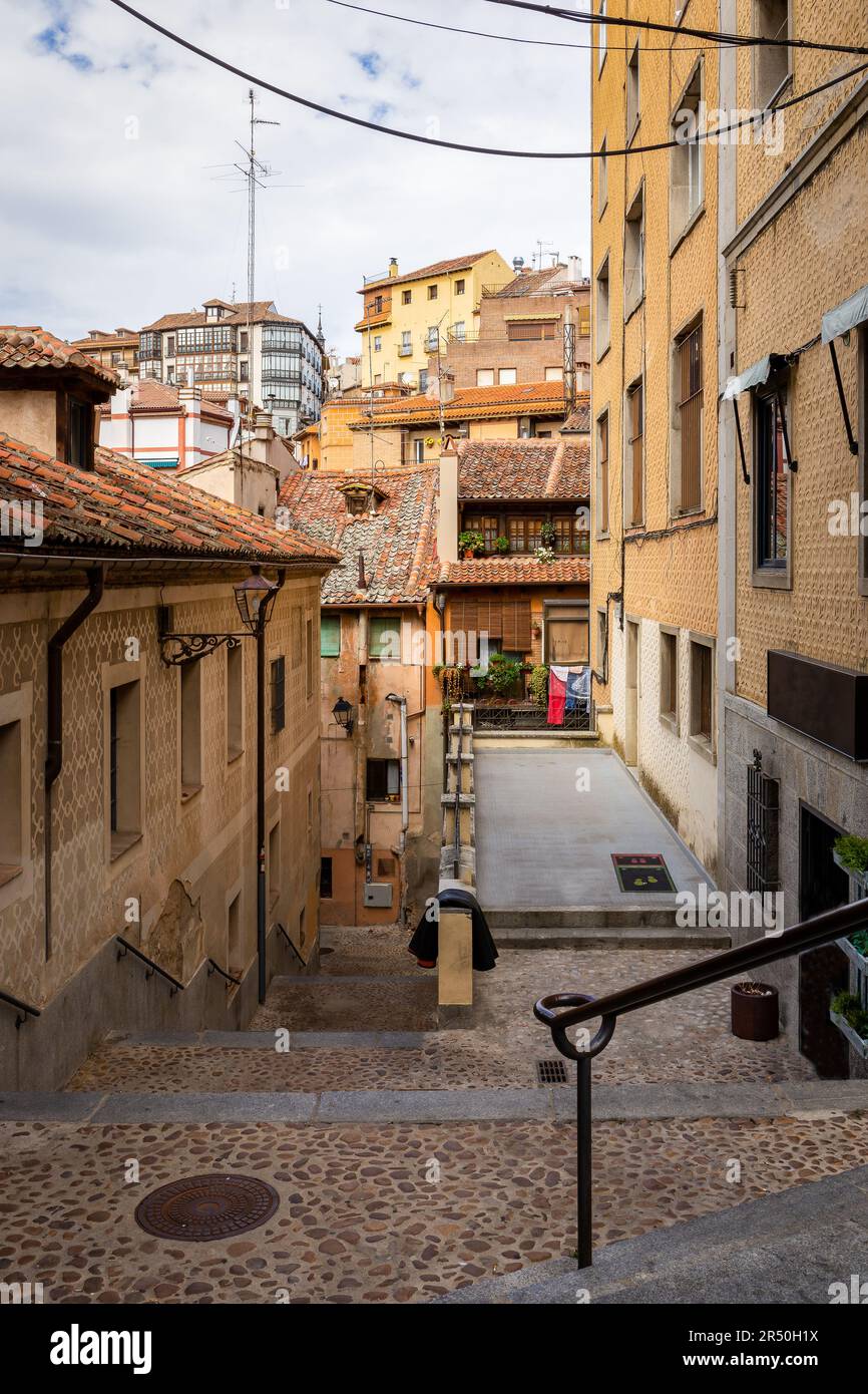Segovia, Spanien, schmale Stadtstraße, traditionelle mediterrane Wohngebäude mit dekorativen Fassaden und Ziegeldächern. Stockfoto