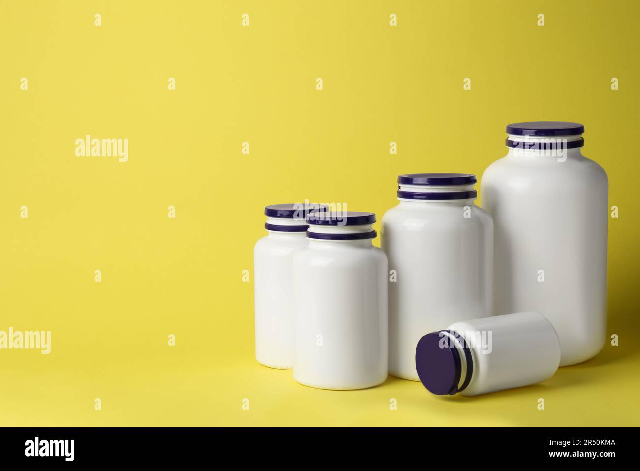 Viele Arzneimittelflaschen auf gelbem Hintergrund, Platz für Text Stockfoto