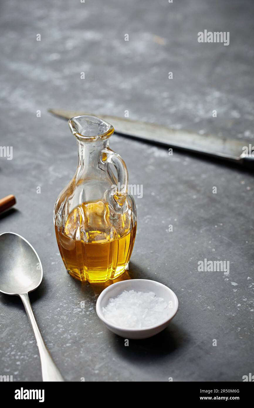 Olivenöl in einer Glasflasche mit Meersalz an der Seite Stockfoto