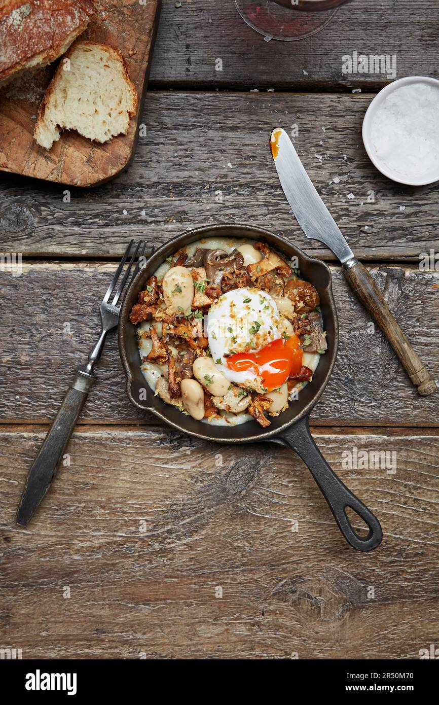 Pilz- und Cannellini-Bohnen-Gericht mit pochiertem Ei Stockfoto