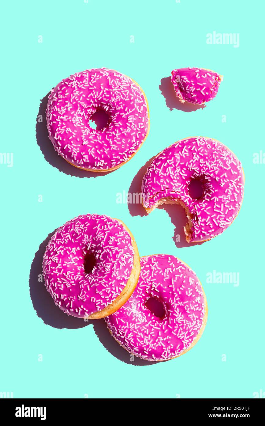 Donuts mit rosafarbener Glasur auf türkisfarbenem Hintergrund Stockfoto