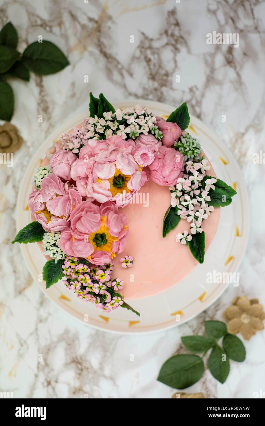 Schokoladen- und Mandel-Buttercreme-Kuchen mit Blumendekorationen Stockfoto