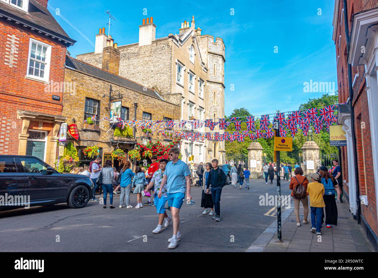 Vor dem Pub Two Brewers in Windsor, Berkshire, Großbritannien, herrscht eine lebhafte Atmosphäre, in der die Menschen im Biergarten trinken und die Straße mit Union Jack Wings verzieren. Stockfoto