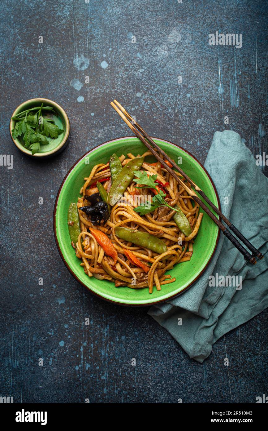 Gebratene udon-Nudeln mit Huhn, Gemüse und Pilzen Stockfoto