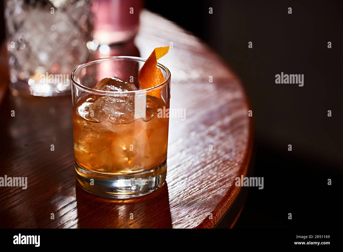 Cocktail mit Eis und Orangenschale auf dem Tisch Stockfoto