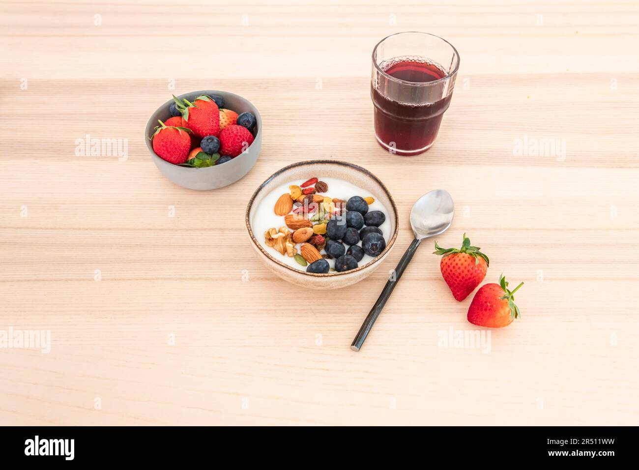 Schüssel Joghurt mit Nüssen und Beeren Stockfoto