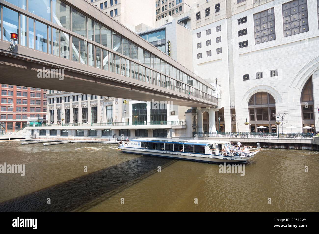USA, Milwaukee, Touristenboot, das unter der Fußgängerbrücke entlang des Milwaukee River vorbeifährt. Stockfoto