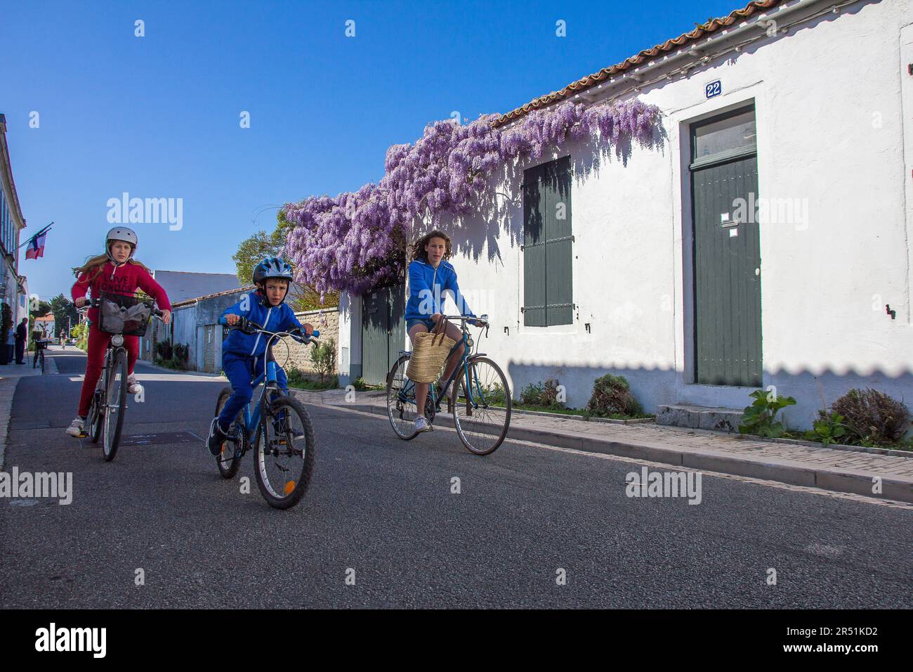 Cyclistes dans les rues des portes en ré, Ile de Ré, Frankreich Stockfoto