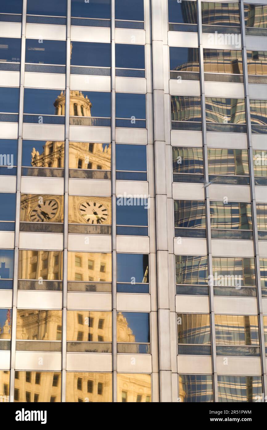 USA, Illinois, Chicago, der Uhrenturm des Wrigley Building spiegelt sich in Glasfenstern. Stockfoto