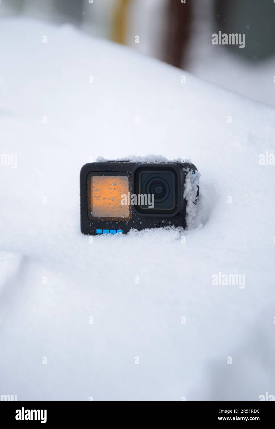 Action-Kamera im Schnee mit Sonnenuntergang auf dem Bildschirm Stockfoto