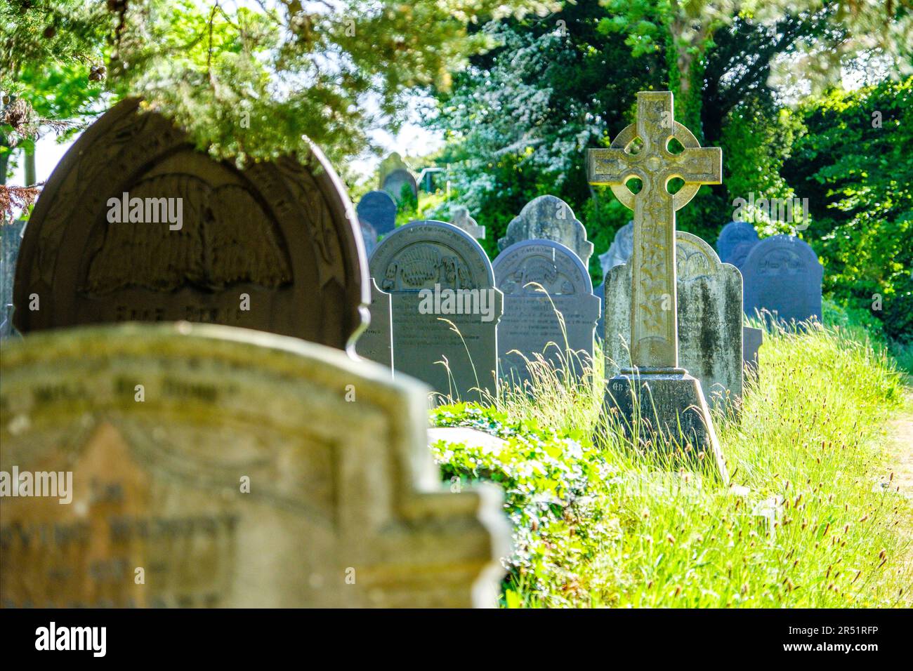 Keltisches Kreuz im Friedhof von Eglwys Sant Tysilio / St. Tysilio's Kirche auf einer Gezeiteninsel in der Menai Straights, Anglesey, Wales Stockfoto