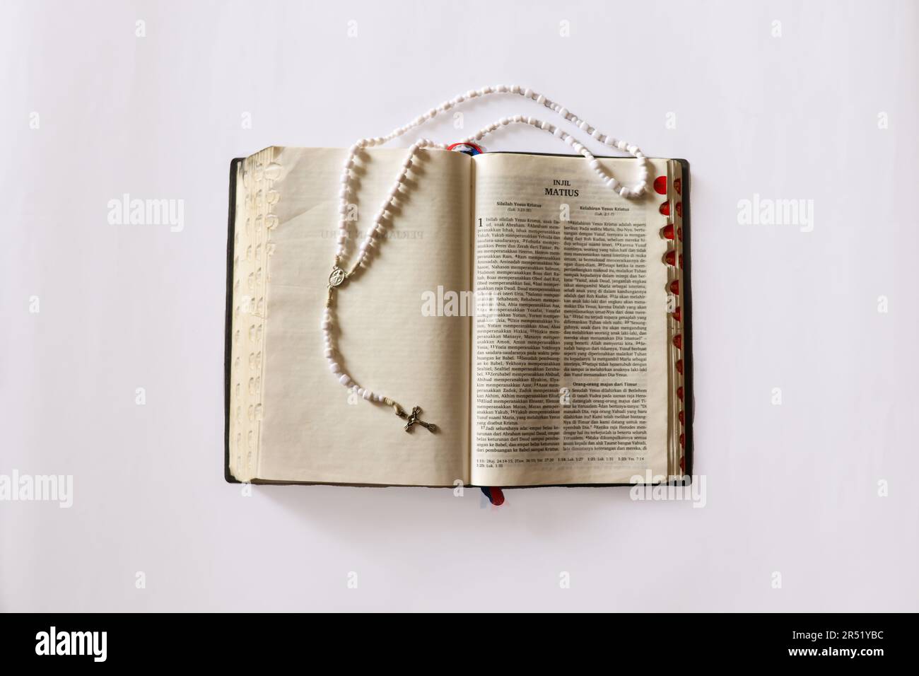 Bibel und Rosenkranz (Gebetsperlen) übereinander. Die Bibel ist eines der meistübersetzten Werke Stockfoto