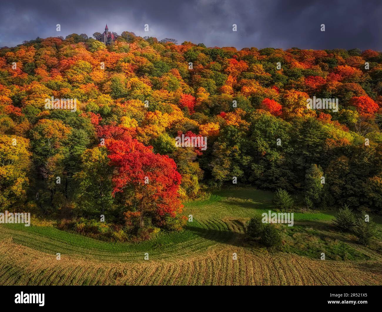 NY Fall Foliage - die farbenfrohe Herbstlandschaft im Hudson Valley, New York, aus der Vogelperspektive. Sehen Sie einen Gipfel des Berges mit einer Burg. Stockfoto