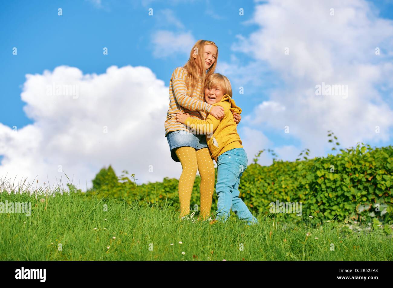 Porträt von 2 lustigen Kindern, die draußen zusammen spielen Stockfoto