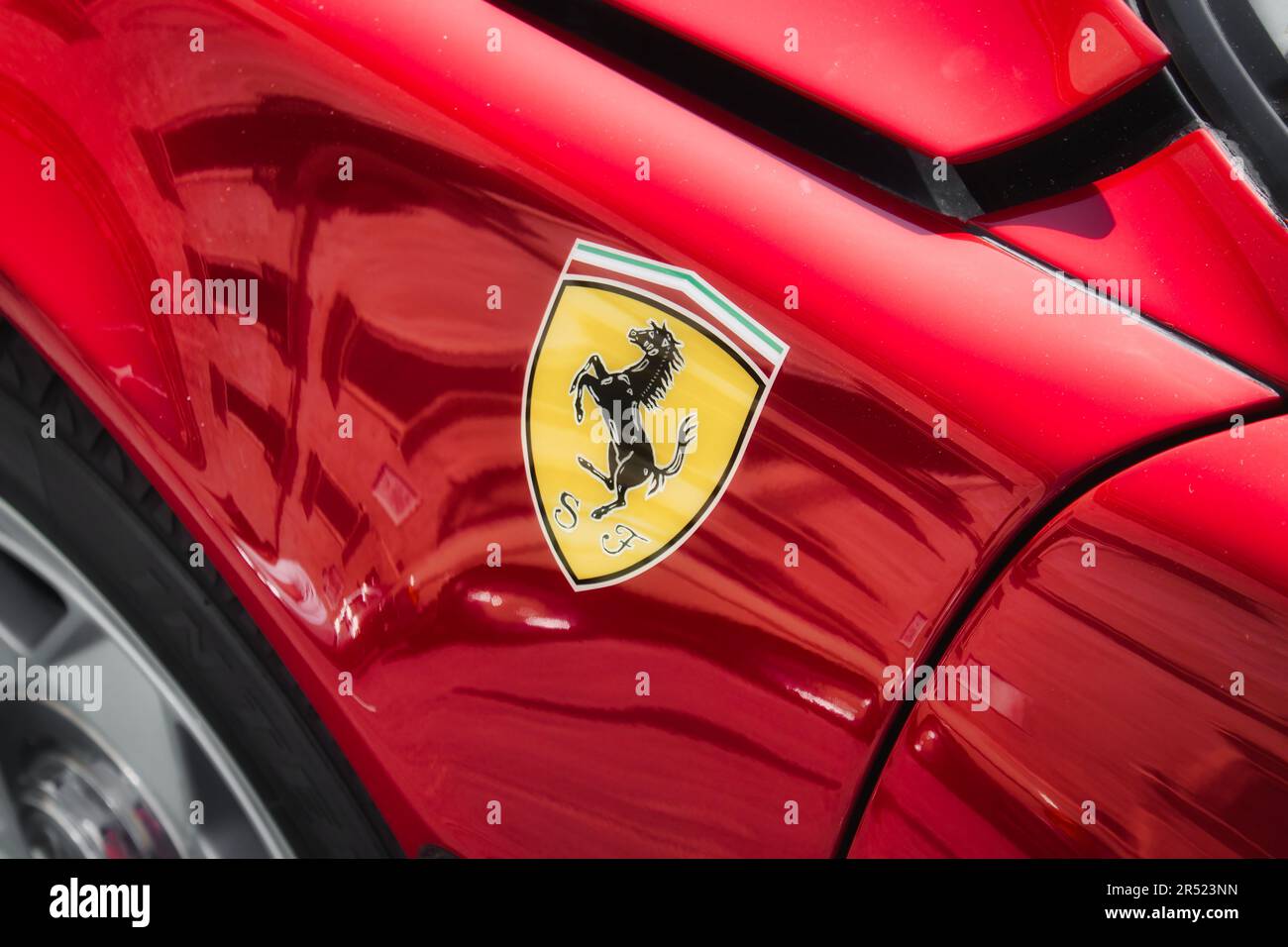 Seitenansicht eines roten, luxuriösen Sportwagens der Marke Ferrari mit schwarzem Pferdelogo auf der Karosserie, keine Personen Stockfoto