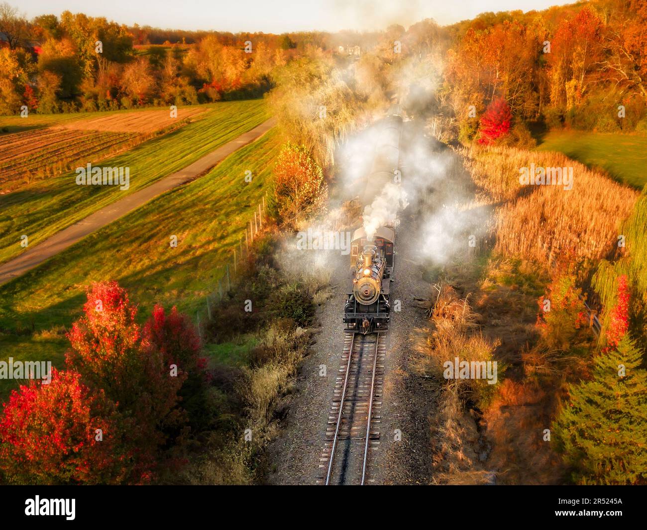 Dampfeisenbahn Nr. 40 - Blick aus der Vogelperspektive auf die Baldwin Locomotive Works Dampfeisenbahn Nr. 40, die während der goldenen Stunde fährt und von der warmen Farbe umgeben ist Stockfoto