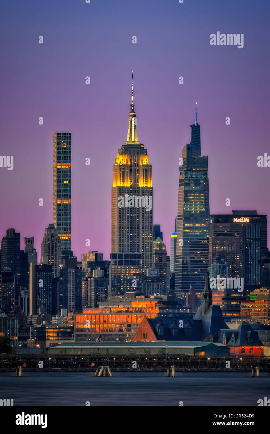 NJ und New York City Skyline - Blick auf das CRRNJ Terminal in Jersey City, New Jersey, in den goldenen Farben, die von der untergehenden Sonne reflektiert werden. Stockfoto