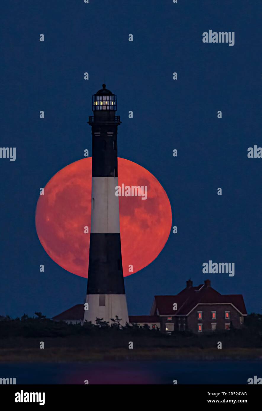 Fire Island Lighthouse Moonrise - der Vollmond erhebt sich hinter dem Fire Island Lighthouse. Der Fire Island Lighthouse ist der höchste Leuchtturm auf Lon Stockfoto