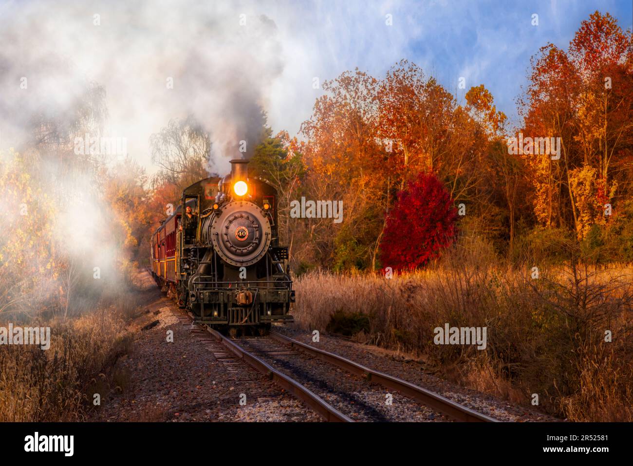 Dampfeisenbahn Nr. 40 PA - Blick auf die Baldwin Locomotive Works Dampfeisenbahn Nr. 40, die während der goldenen Stunde fährt und von warmen Farben umgeben ist Stockfoto