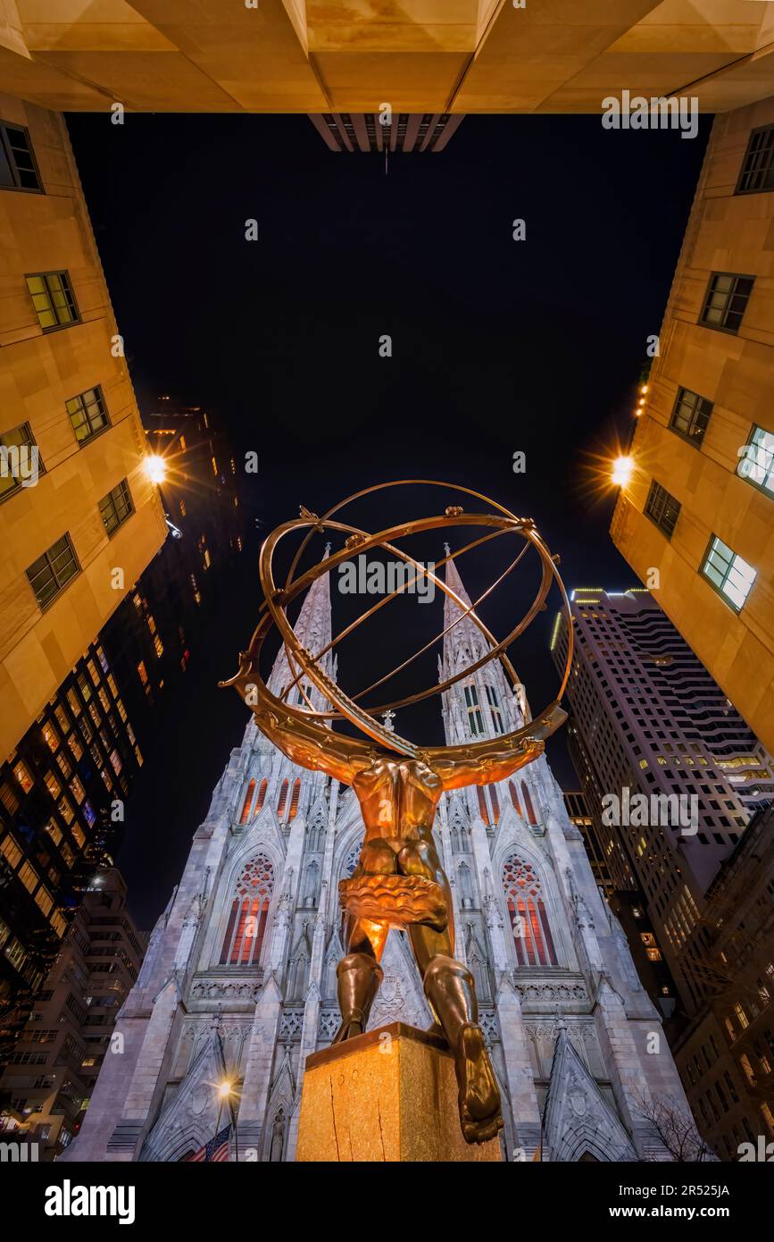 Saint Patricks Cathedral NYC - Blick hinter der Atlasstatue auf die gotische Wiedergeburt und den englisch-gotischen Architekturstil der Saint Patrick Cathedra Stockfoto
