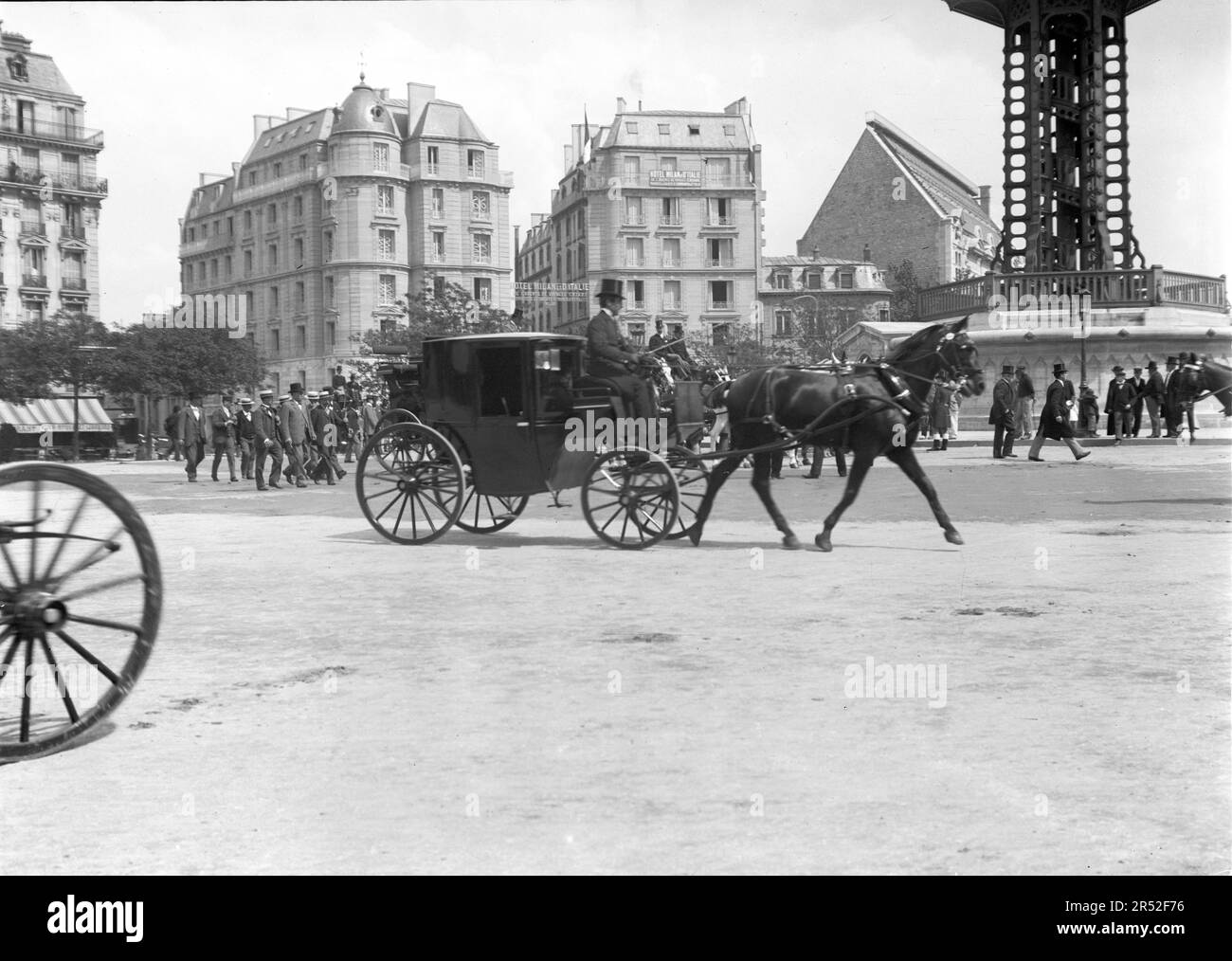 Anfang des 20. Jahrhunderts fährt eine Pferdekutsche durch einen Ort in Paris. Das ist ein altes Foto, das aus Glasplatten digitalisiert wurde. Stockfoto