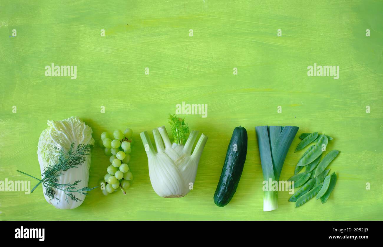 Gesunde Lebensmittel, Selleriekohl, Trauben, Fenchel, Gurken, Schneebohnen, Lauch, freier Kopierbereich, auf grünem Hintergrund, Konzept, Flach liegend, Stockfoto