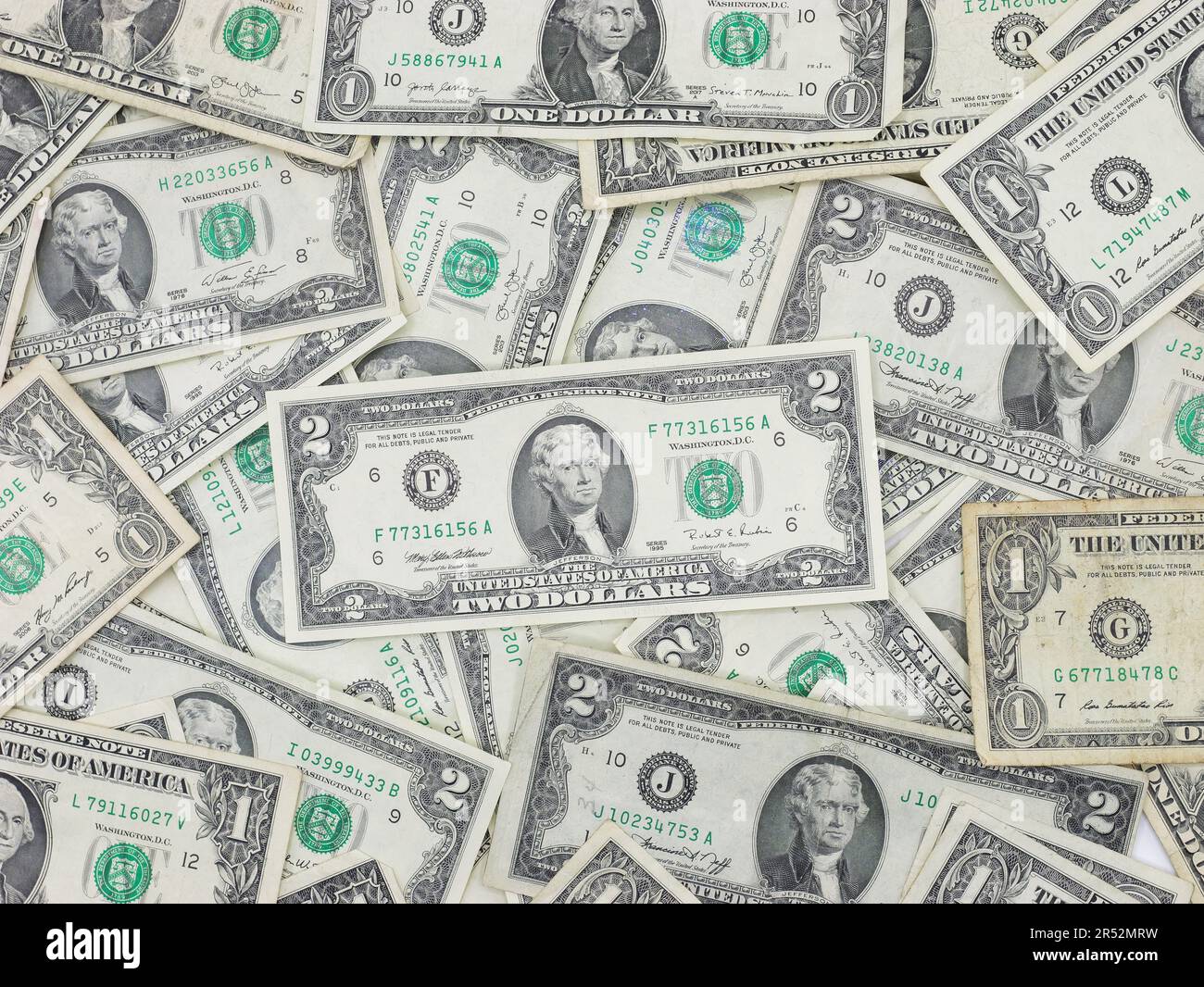 Zahlreiche ein- und zwei-Dollar-Scheine, die flach auf einem Tisch liegen – Ungerade, einzigartige US-Währung Stockfoto