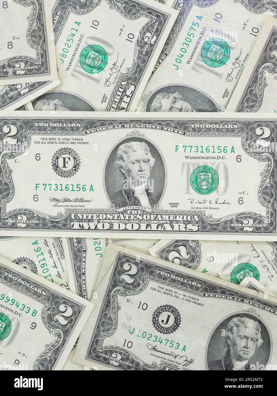 Zahlreiche zwei-Dollar-Scheine, die flach auf einem Tisch liegen – ungerade, einzigartige US-Währung Stockfoto