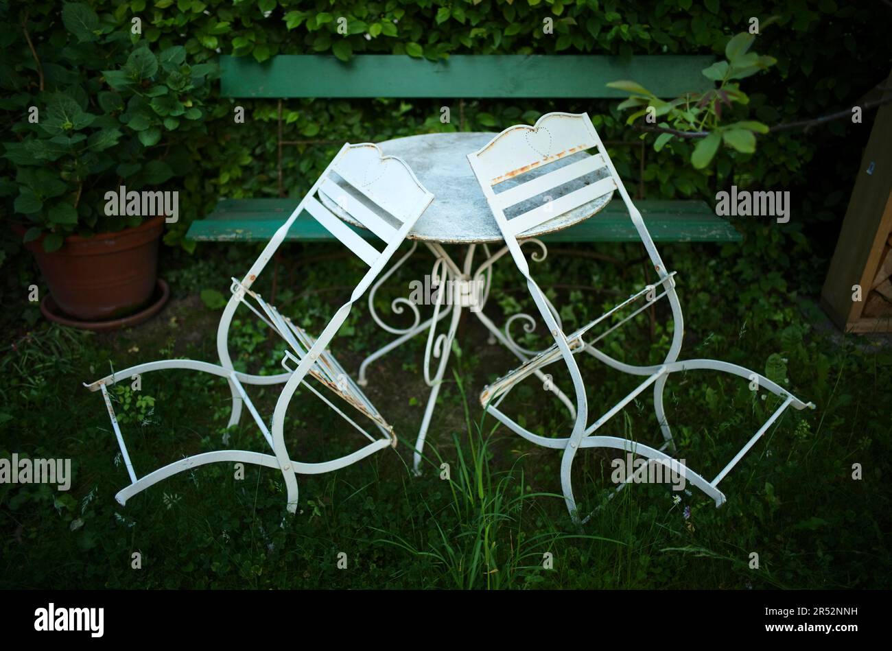 Metallstühle, Metalltisch und Holzbank im Garten, Stuttgart, Baden-Württemberg, Deutschland Stockfoto