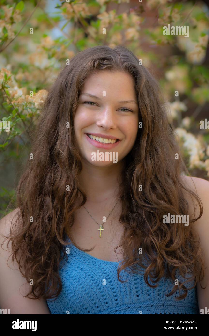 Schöne junge lächelnde Frau mit langen braunen Haaren Stockfoto